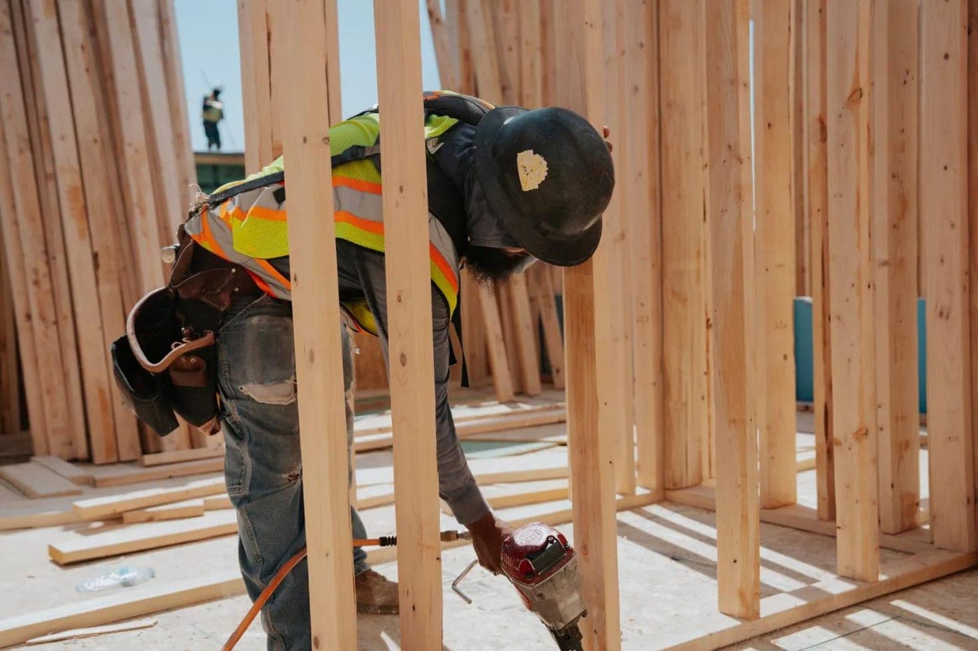 Carpenter fastening wall framing on a residential build